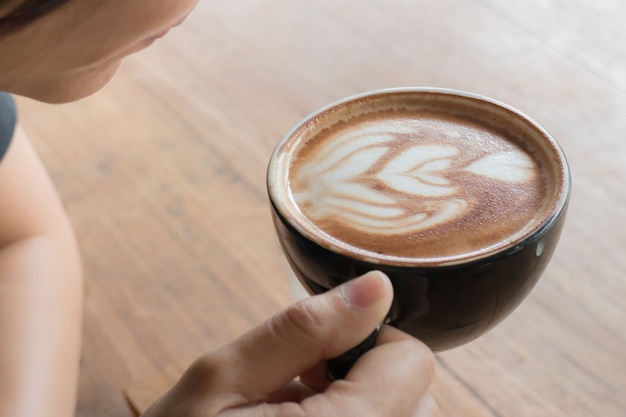 Mano sul caffè caldo latte