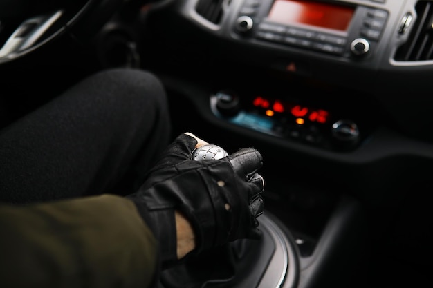 Mano sul pomello del cambio dell'auto. Il conducente cambia la velocità in macchina. Mano sulla leva del cambio.