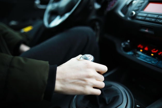 Mano sul pomello del cambio dell'auto. Il conducente cambia la velocità in macchina. Mano sulla leva del cambio.