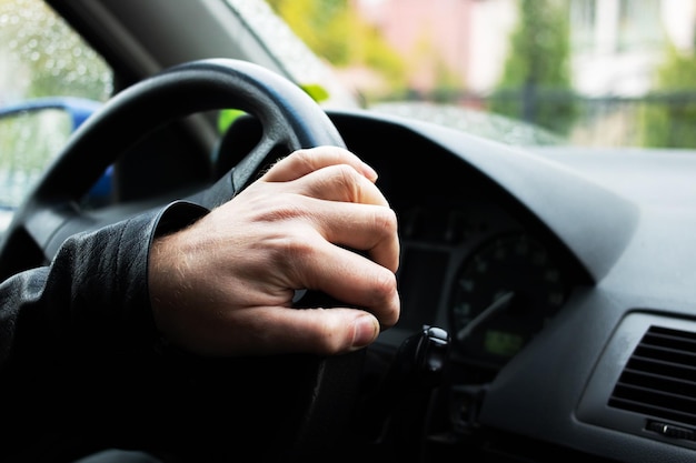 Mano sul volante di un'auto