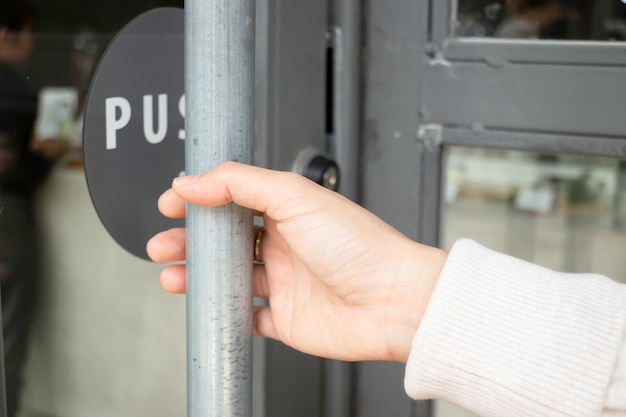 Mano sulla maniglia per aprire la porta del ristorante