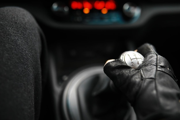 Mano sulla manopola del cambio dell'auto Il conducente cambia la velocità nell'auto Mano sulla leva del cambio