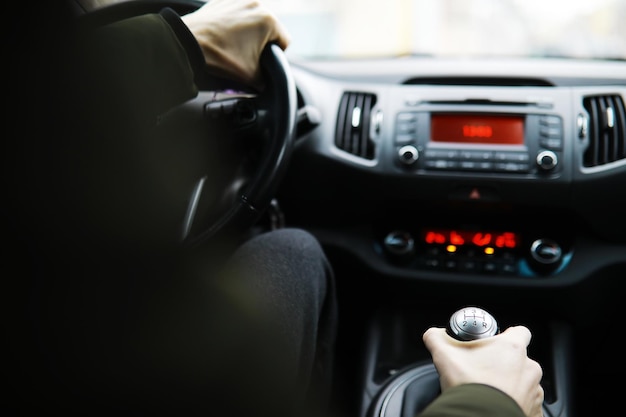 Mano sulla manopola del cambio dell'auto Il conducente cambia la velocità nell'auto Mano sulla leva del cambio