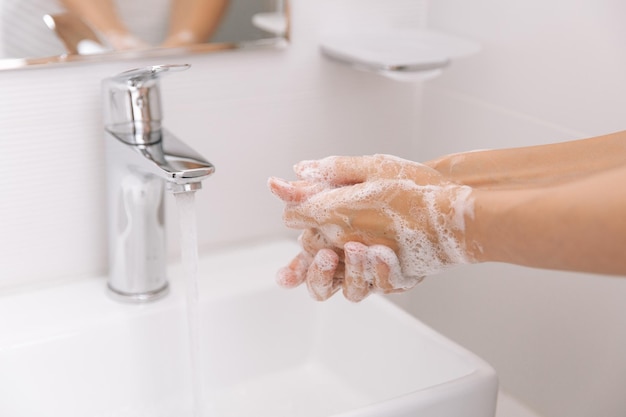 Mano tagliata che si lava le mani in bagno