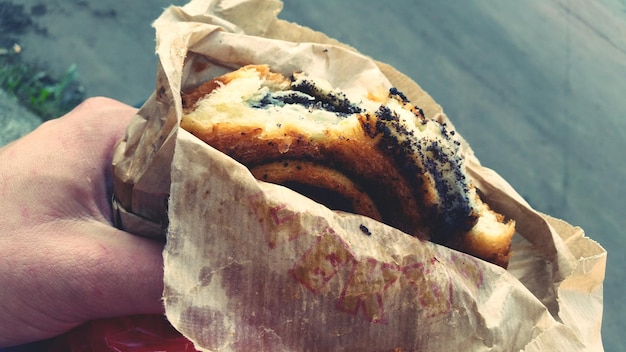 Mano tagliata che tiene il cibo a tavola