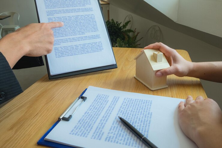 Foto mano tagliata di un agente che discute con un cliente alla scrivania dell'ufficio