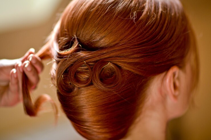 Foto mano tagliata di un parrucchiere che tiene i capelli di una donna al salone