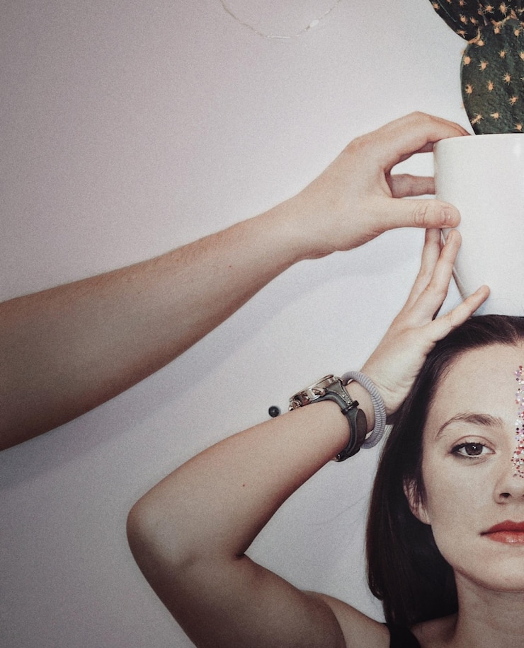 Foto mano tagliata di un uomo che tiene un cactus in vaso sulla testa di un'amica