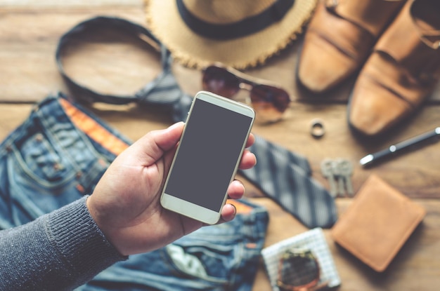 Mano tagliata di un uomo che usa il telefono a tavola