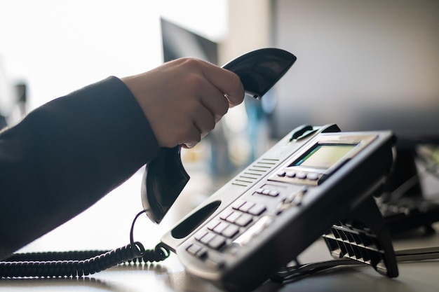 Mano tagliata di un uomo che usa il telefono in ufficio