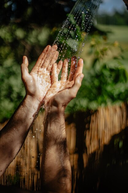 Mano tagliata di un uomo sotto l'acqua spruzzata