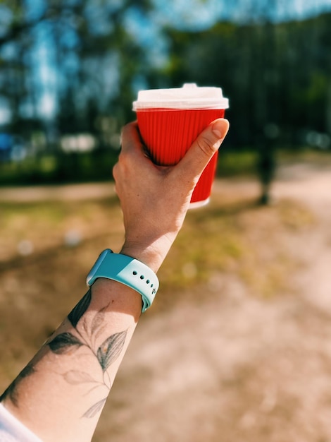 Mano tagliata di una donna che tiene il caffè