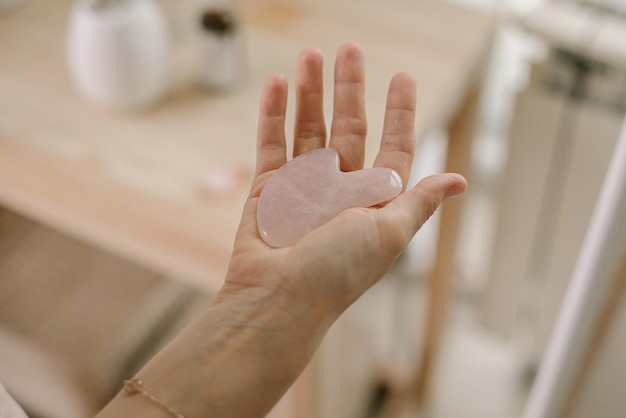 Mano tagliata di una donna che tiene un rullo di giada