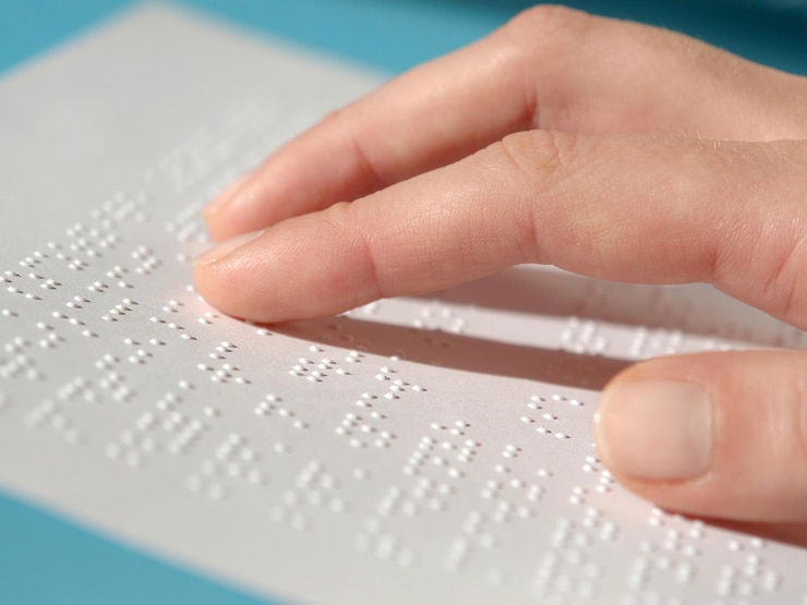 Foto mano tagliata di una donna cieca che legge in braille