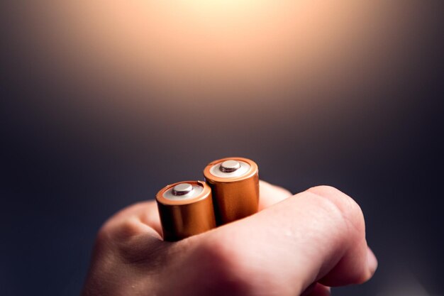 Mano tagliata di una persona che tiene le batterie