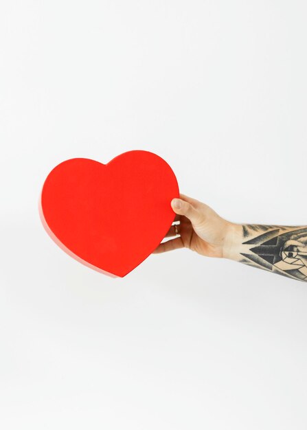 Mano tatuata con un cuore rosso