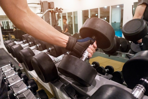 Mano umana che tiene dumbbell in palestra