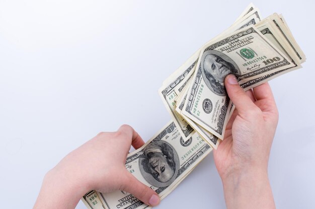 Mano umana che tiene la banconota da un dollaro americano come denaro isolato su bianco