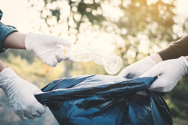 Mano umana raccogliendo vuoto di plastica bottiglia sul parco