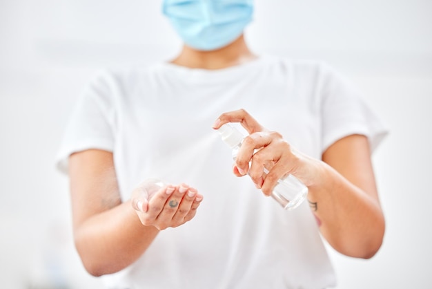 Mantenersi al sicuro e pulito. Inquadratura di una donna che si spruzza le mani con un disinfettante.