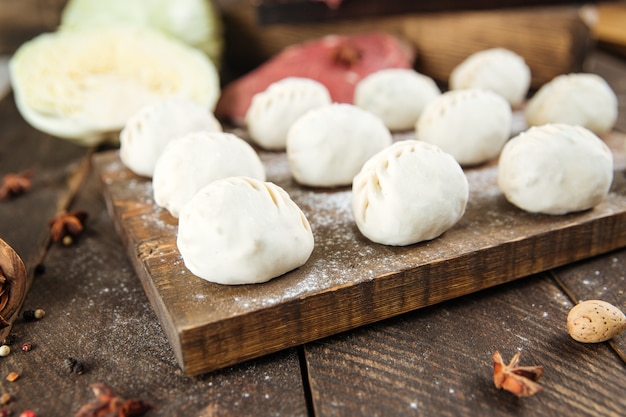 Manti crudo crudo Piatto di carne di gnocchi tradizionali dell'Asia centrale con carne, patate e cipolle