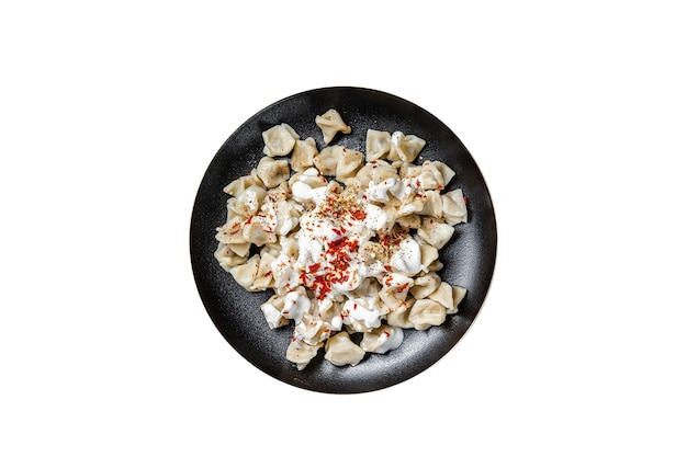 Manti turco con yogurt e salsa di pomodoro in un piatto isolato su sfondo bianco