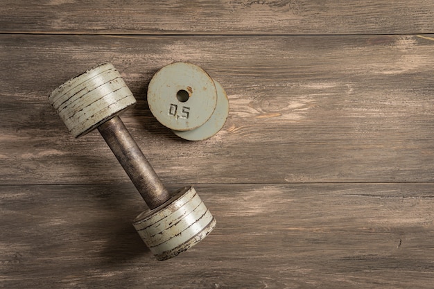 Manubri su fondo di legno bianco, fitness e concetto di salute.