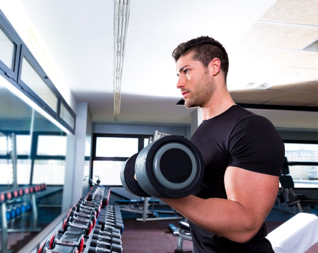 Manubri uomo in palestra allenamento bicipiti fitness