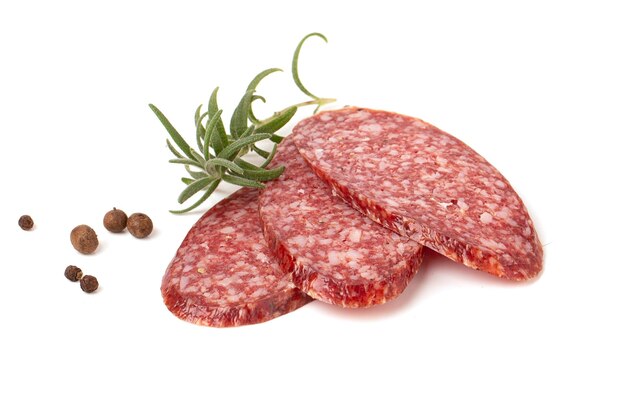 Manzo essiccato salame affumicato salsiccia affettata con ramo di rosmarino e pepe piselli closeup isolato su uno sfondo bianco