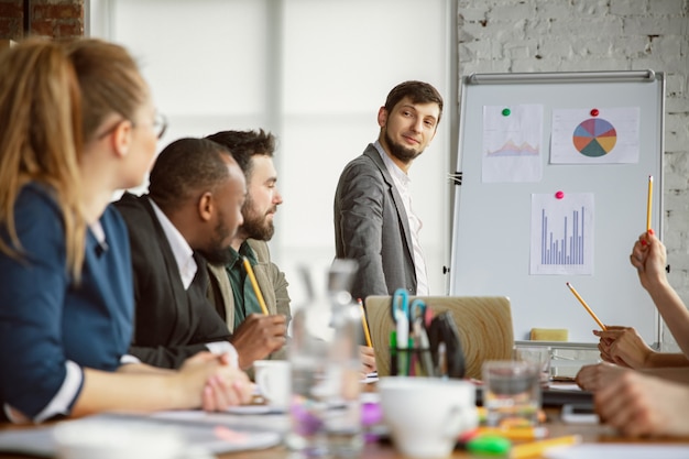 Mappatura del cervello. Gruppo di giovani professionisti che hanno una riunione. Diversi gruppi di colleghi discutono di nuove decisioni, piani, risultati, strategia. Creatività, posto di lavoro, affari, finanza, lavoro di squadra.