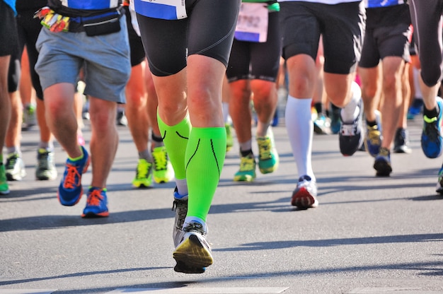 Maratona di corsa, piedi di corridori su strada, sport, fitness e concetto di stile di vita sano