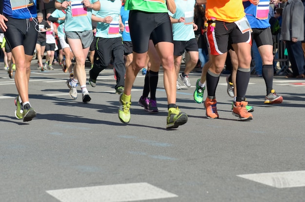 Maratona di corsa, piedi di molti corridori su strada, competizione sportiva, fitness e concetto di stile di vita sano
