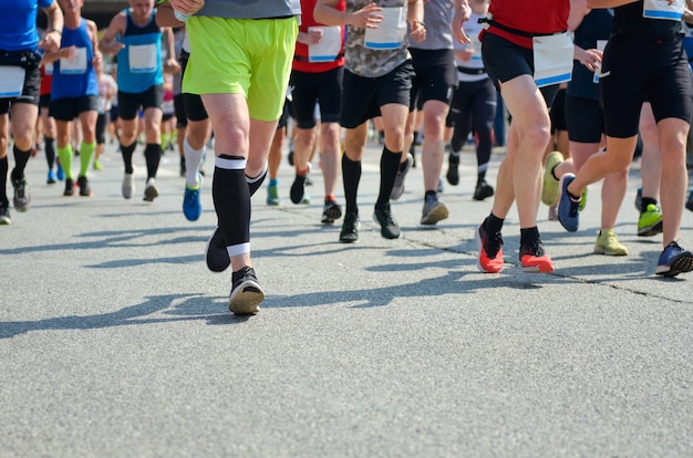 Maratona di corsa, piedi di molti corridori su strada, competizione sportiva, fitness e concetto di stile di vita sano