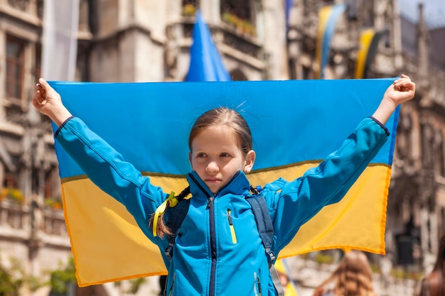 Marcia di protesta contro la guerra. Ragazza con la bandiera dell'Ucraina al Rally per sostenere l'Ucraina a Monaco di Baviera in Germania