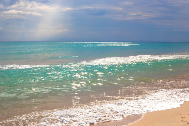 Mare azzurro con un'onda e cielo blu coperto di nuvole Seascape in un giorno d'estate