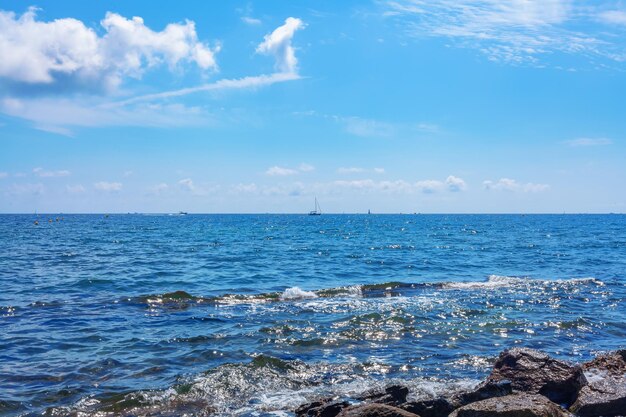 Mare blu sotto il cielo Grandi pietre Onde del mare Paesaggio marino calmo