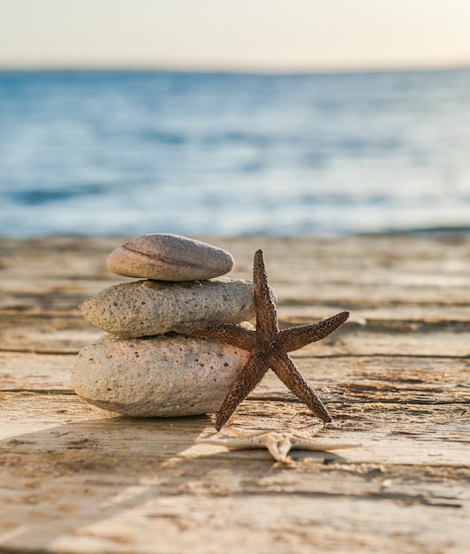 Mare blu sulla superficie Messa a fuoco selettiva, pietre zen sulla spiaggia del mare, meditazione, spa, armonia, calma, concetto di equilibrio