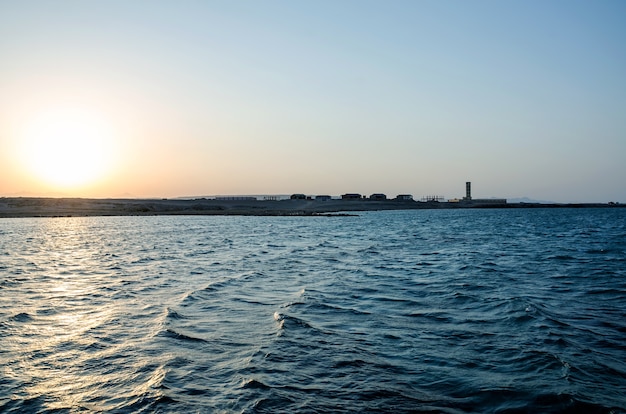 Mare calmo con il cielo al tramonto e il sole tra le nuvole sopra Oceano di meditazione e superficie del cielo Tranquillo paesaggio marino