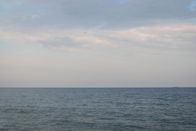 Mare calmo con una nave che naviga in lontananza