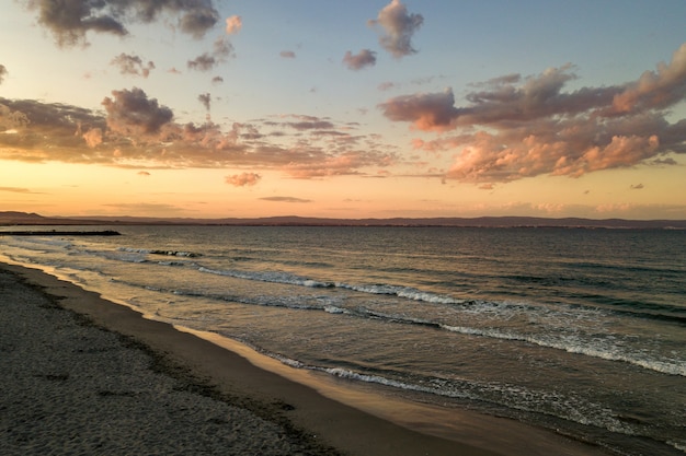 Mare con acqua blu sotto il cielo nuvoloso.