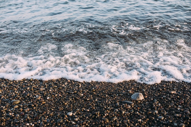 Mare con ciottoli e sassi la sera al tramonto