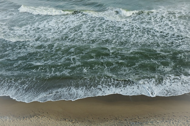 Mare con onde sulla bellissima spiaggia di sabbia