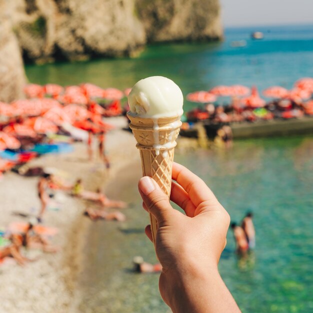 Mare di gelato della stretta della mano della donna su priorità bassa