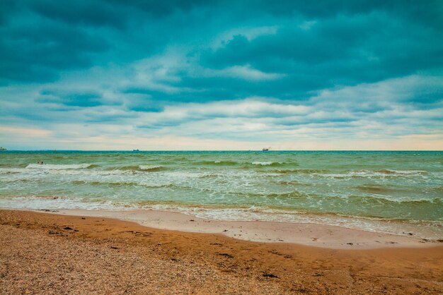 Mare di spiaggia deserta con drammatico cielo tempestoso