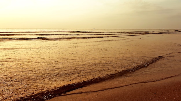 Mare e cielo con nuvole e onde sulla spiaggia al mattino