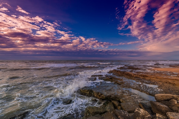 Mare tempestoso e costa rocciosa, bel cielo drammatico