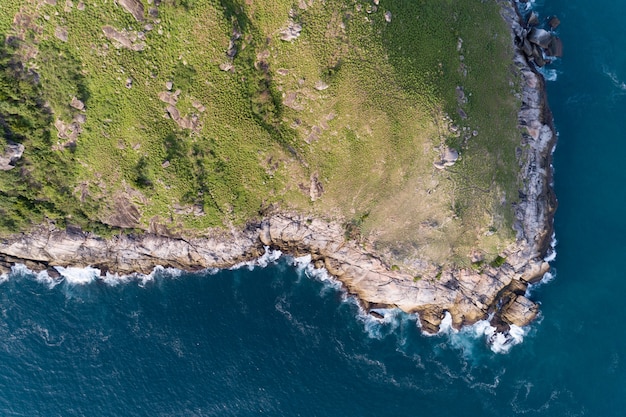 Mare tropicale con onde che si infrangono sulla riva del mare e alta montagna situata