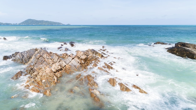 Mare tropicale con onde che si infrangono sulle rocce