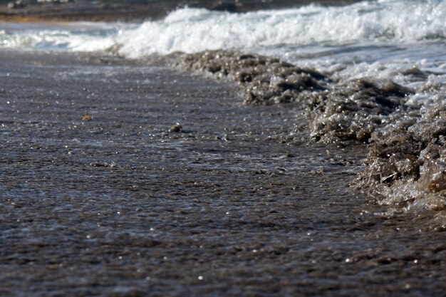 Marea di onde su una spiaggia sabbiosa