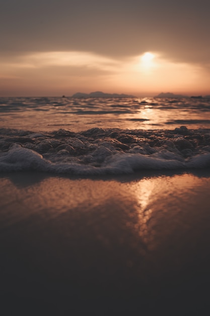 maree e bolle dell'oceano su una spiaggia al tramonto